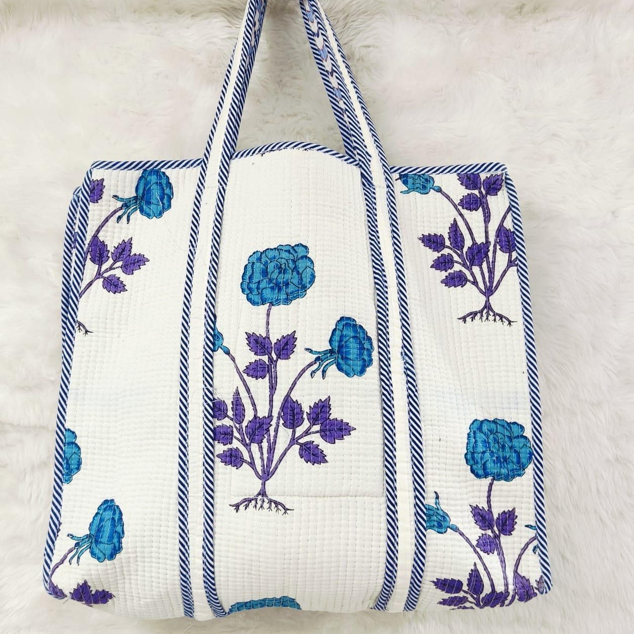Tote bag with blue floral patterns on a white background