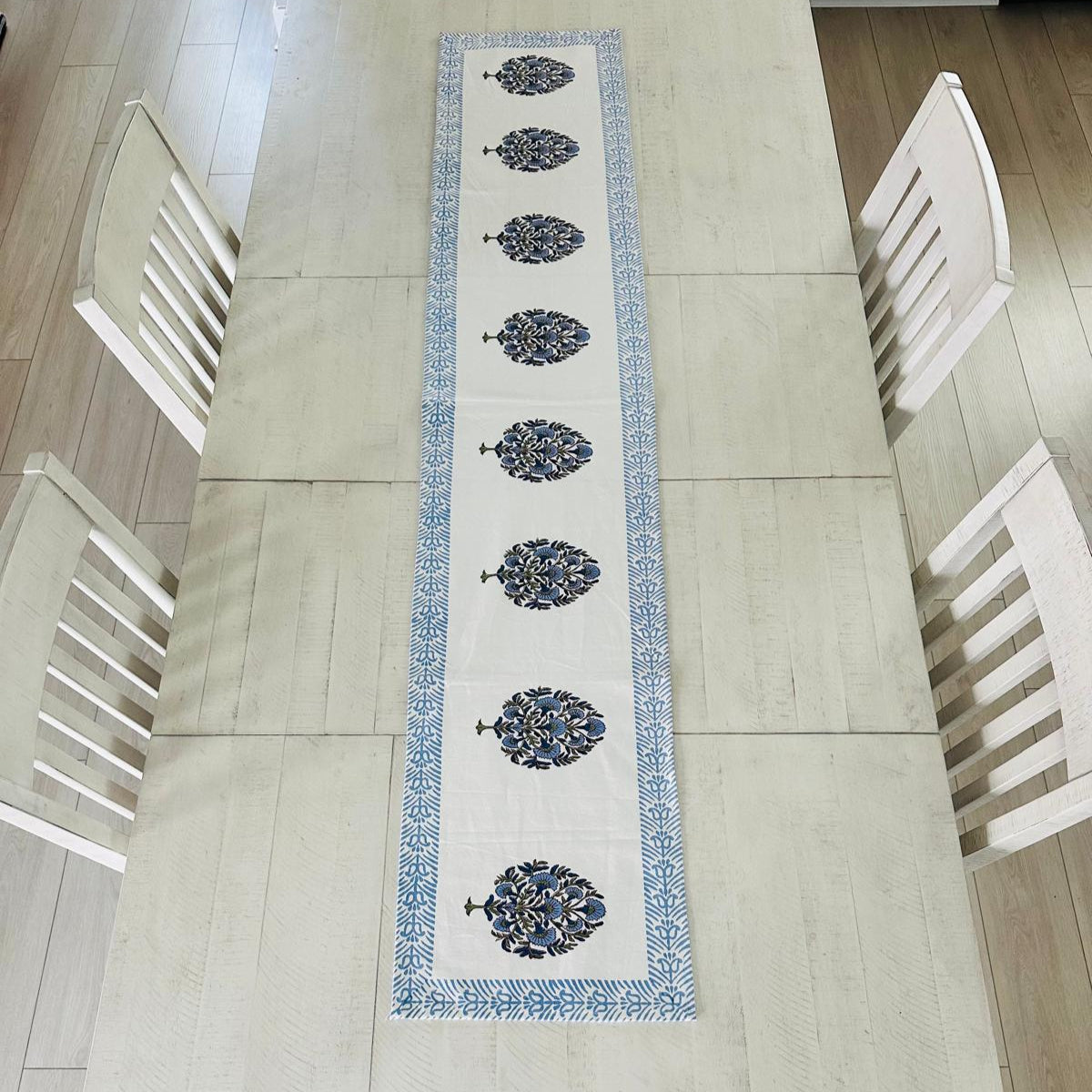 Decorative table runner with floral patterns on a dining table.