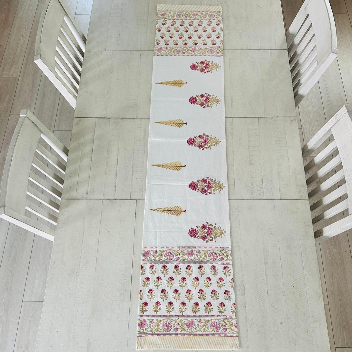 Decorative table runner with floral patterns on a wooden table.