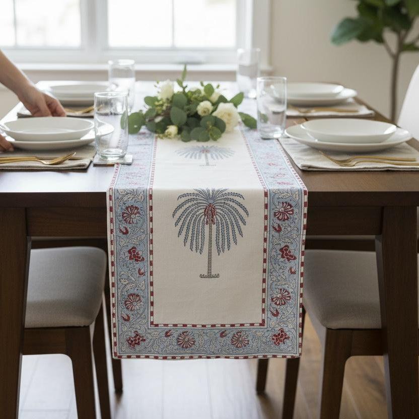 Dining table set with a decorative table runner, glasses, and plates.
