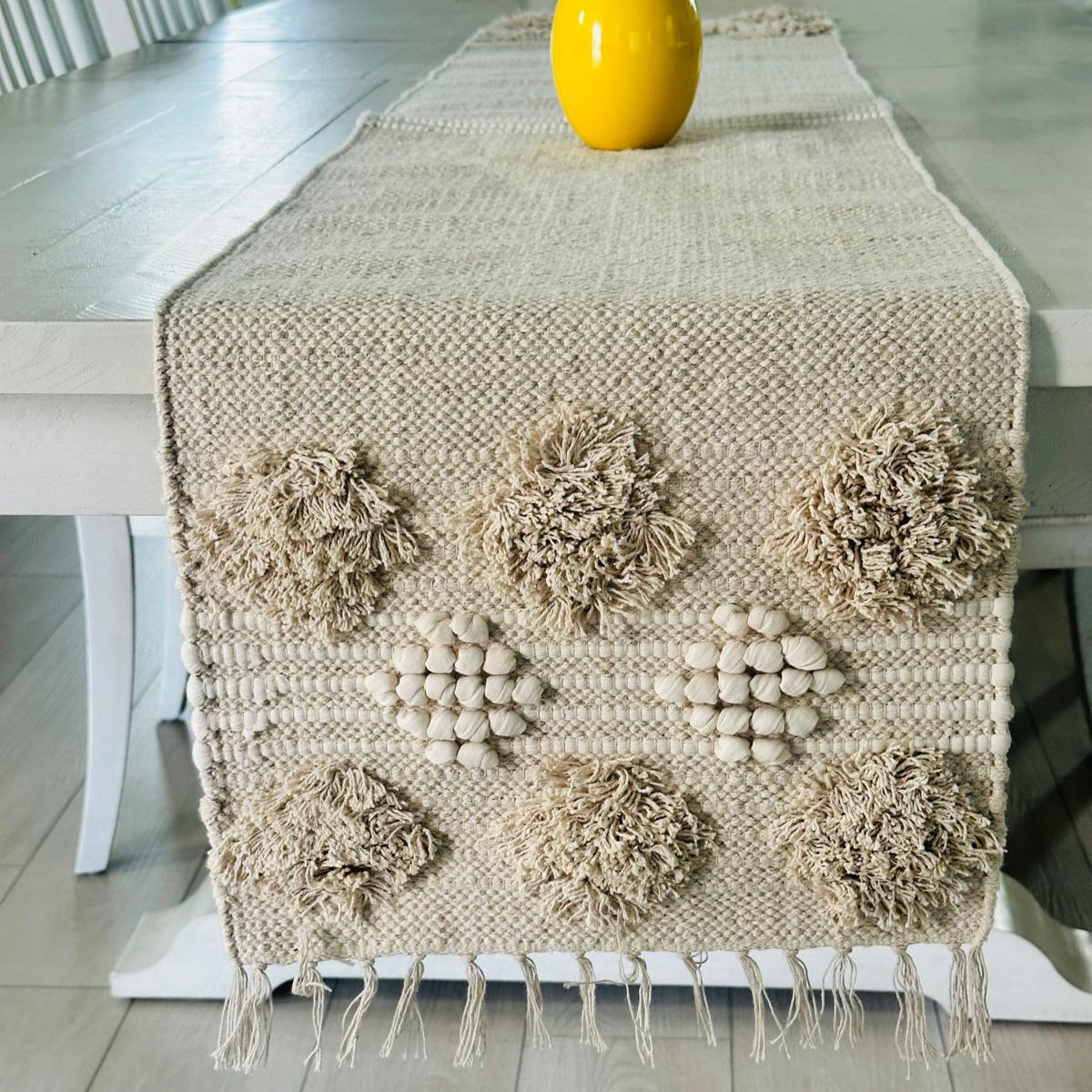 Decorative table runner with floral patterns on a wooden table.