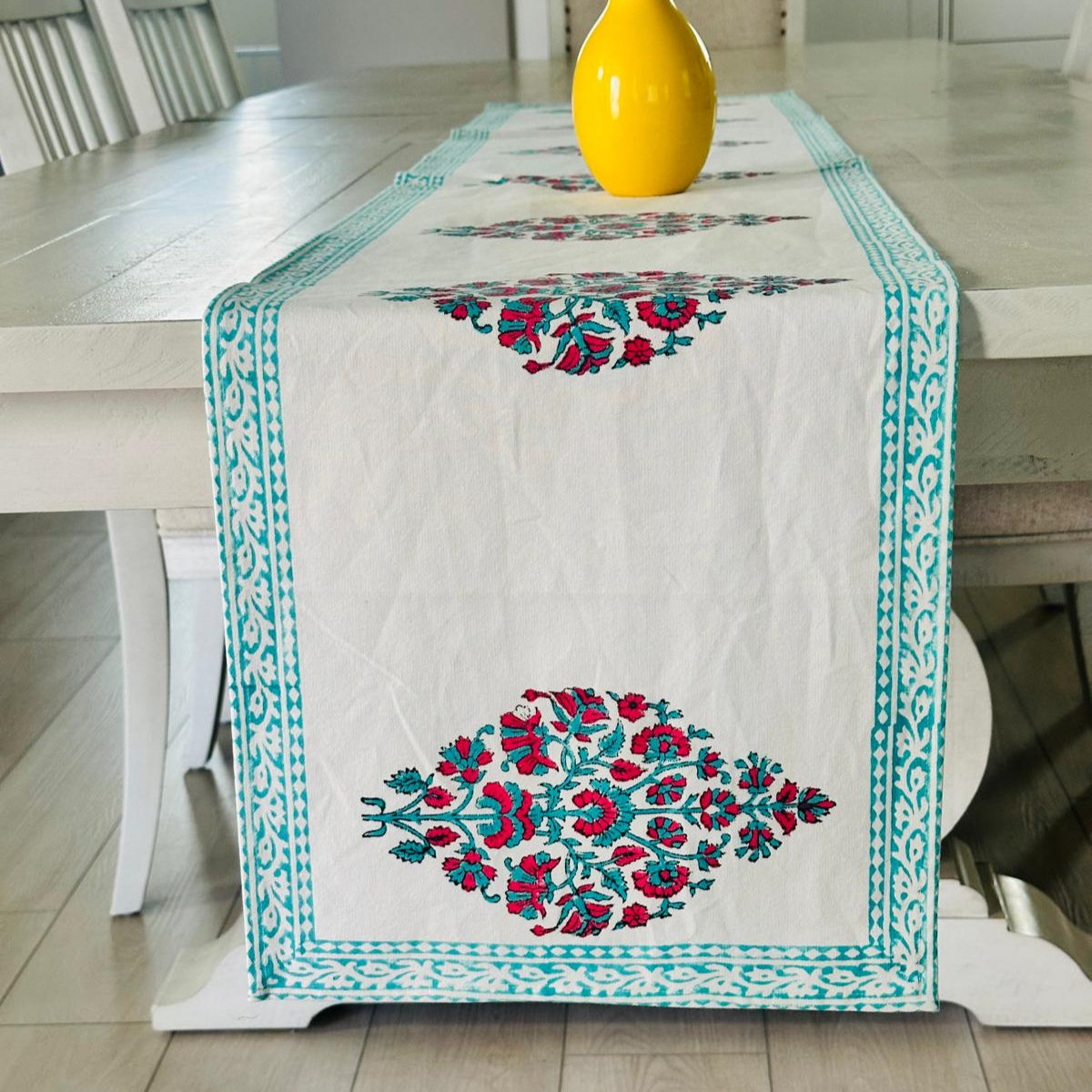 Decorative table runner with floral patterns on a wooden table.