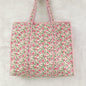 Floral patterned tote bag with pink and green design on a light gray background