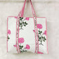 Floral-patterned tote bag with pink flowers and green leaves on a white background