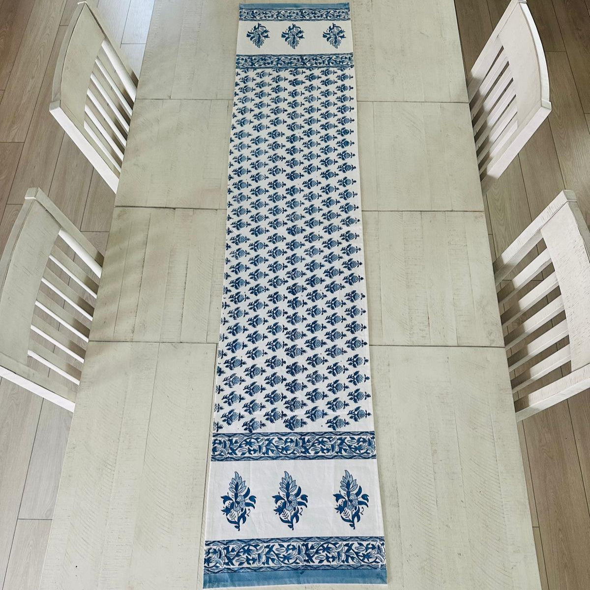 Table runner with blue floral pattern on a wooden table