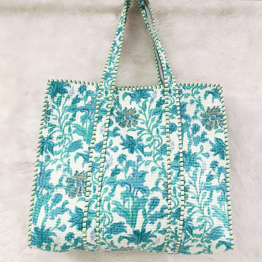 Floral patterned bag with decorative trim on a light background