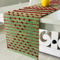 Green and red patterned table runner on a white surface