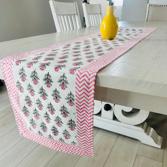 Table runner with pink and white pattern on a wooden table