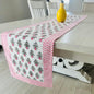 Table runner with pink and white pattern on a wooden table