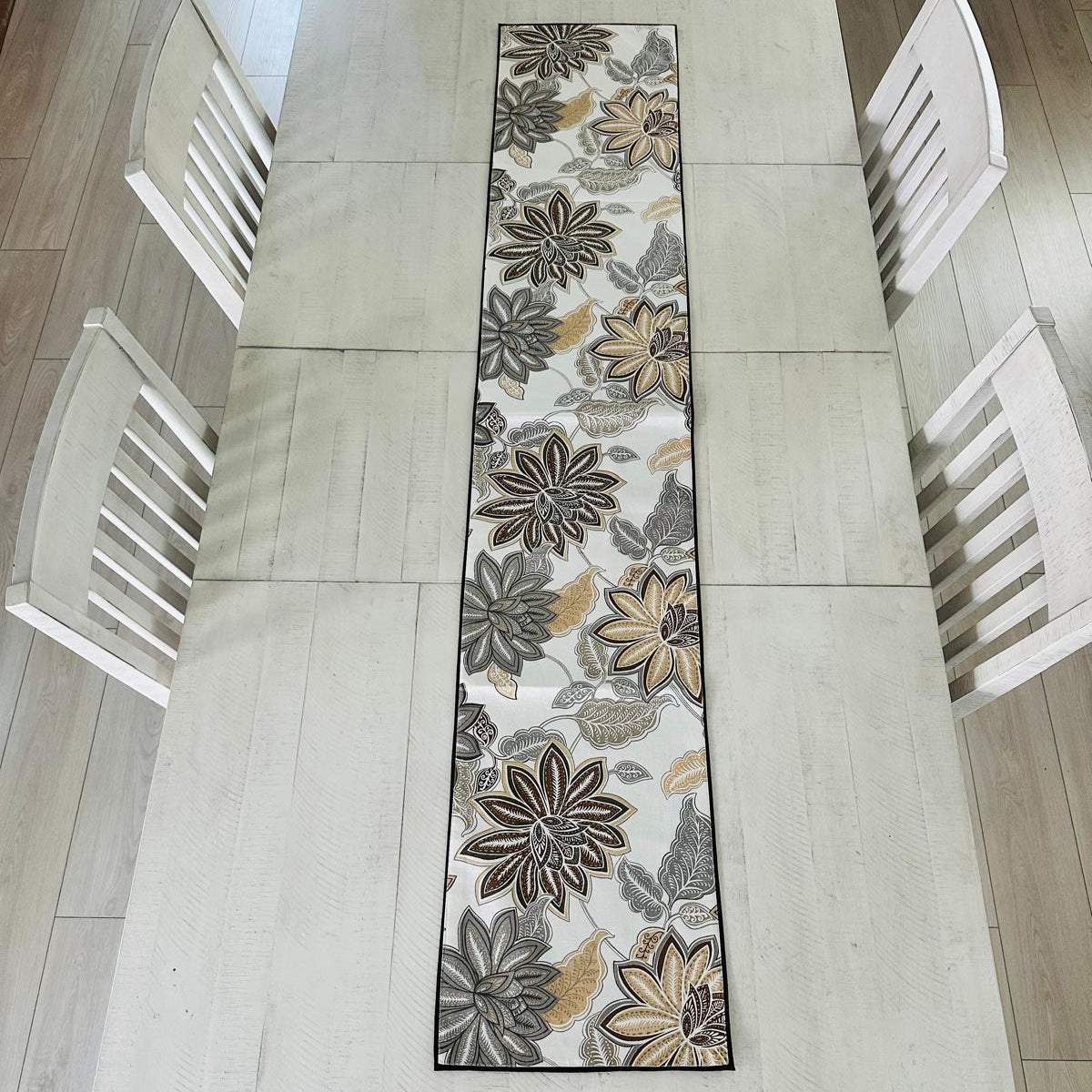 Floral patterned table runner on a dining table with chairs.