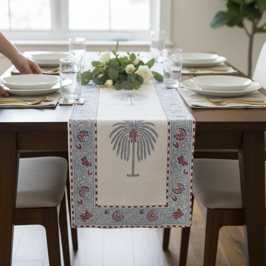 Dining table set with a decorative table runner, glasses, and plates.