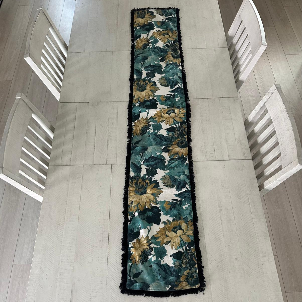 Floral patterned table runner on a dining table with chairs.