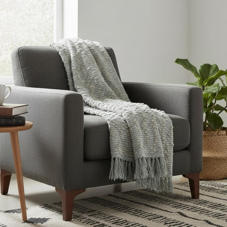 Gray armchair with a blanket in a cozy living room setting